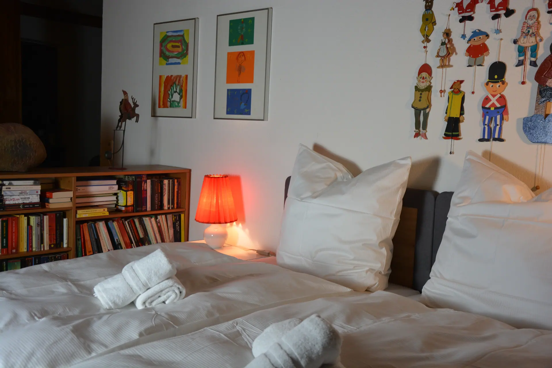Schlafzimmer mit Doppelbett und Bücherregal