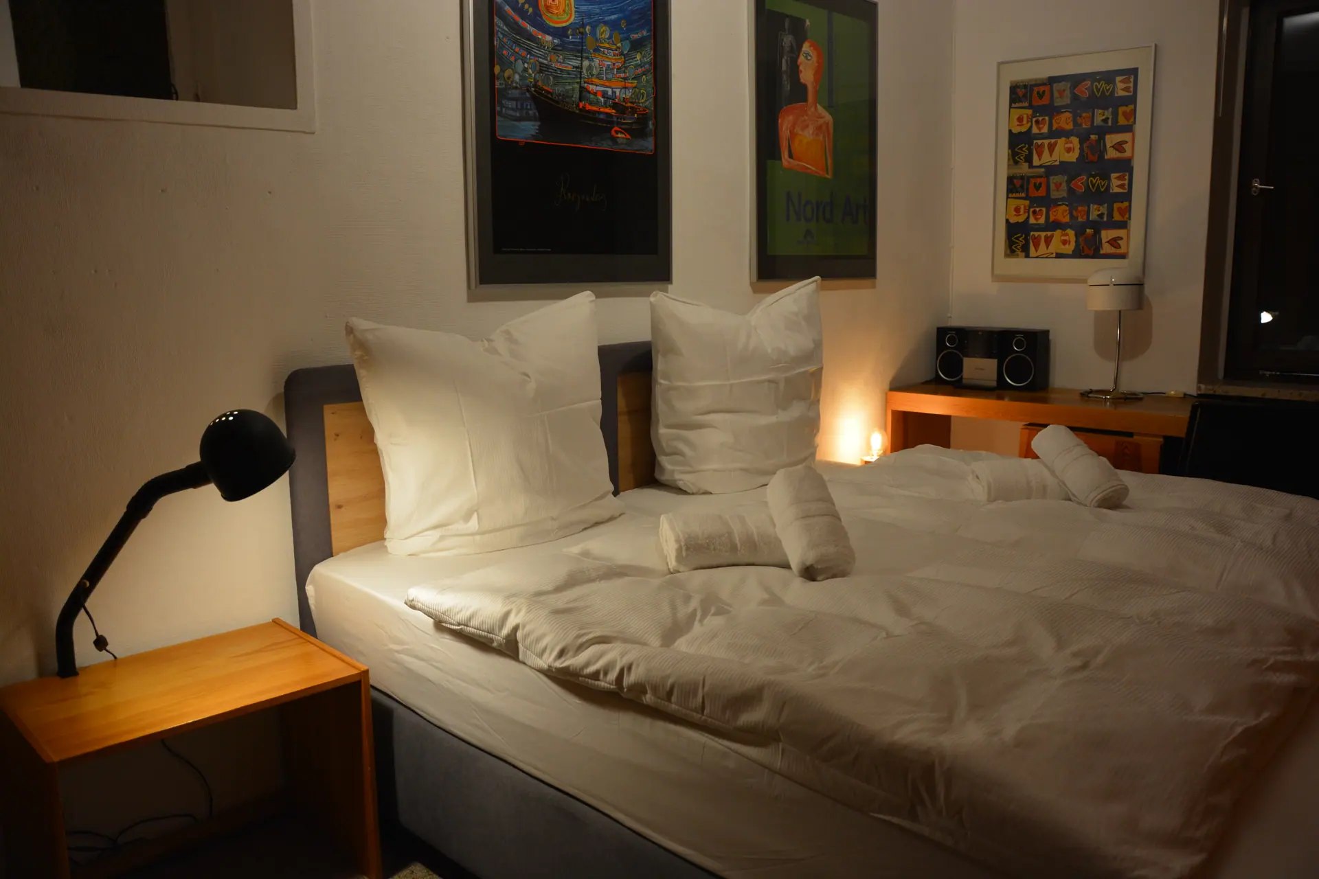 Schlafzimmer mit Doppelbett und Kunstplakaten