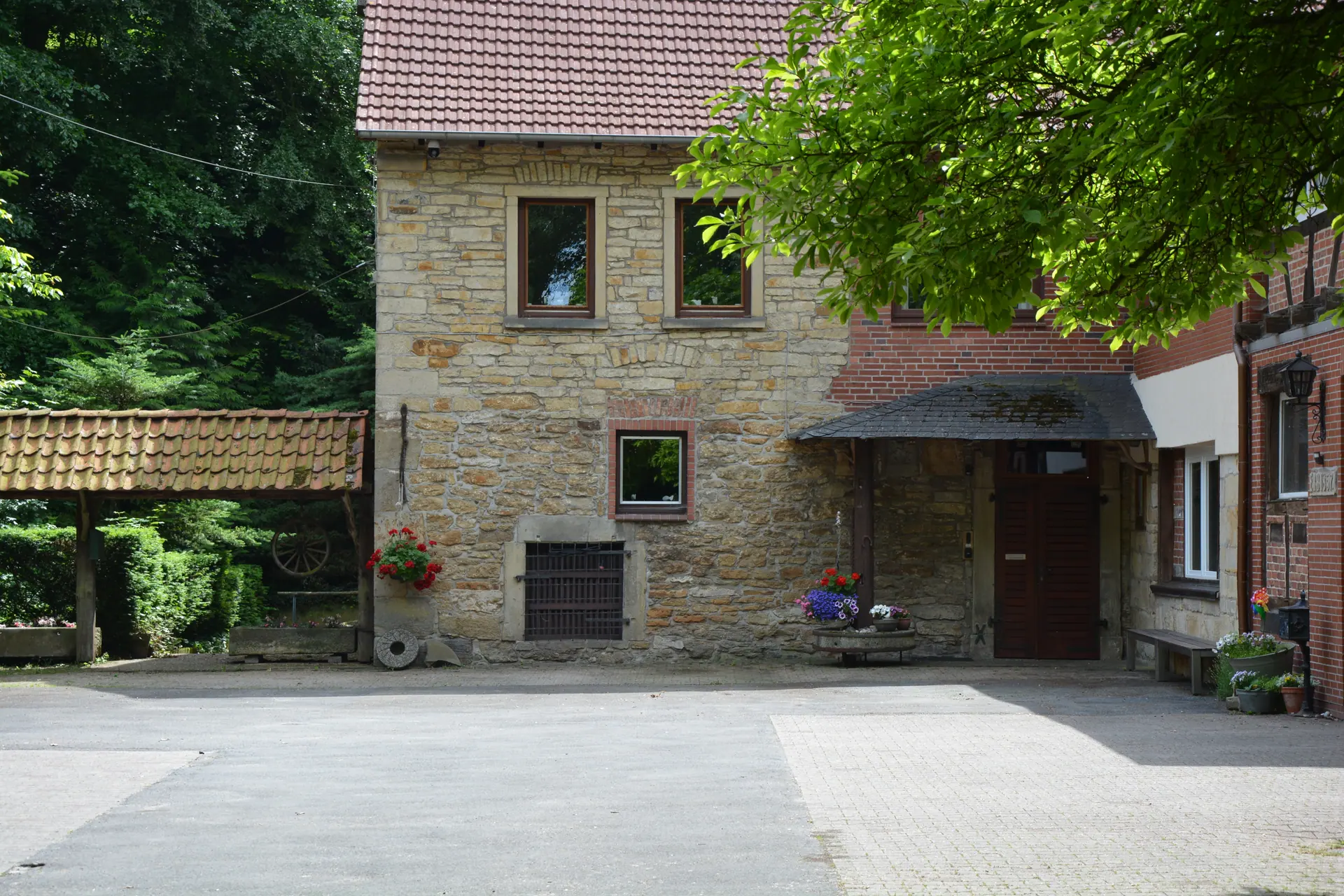 Historische Riesenmühle aus Bruchstein mit Mühlenhof im Sommer